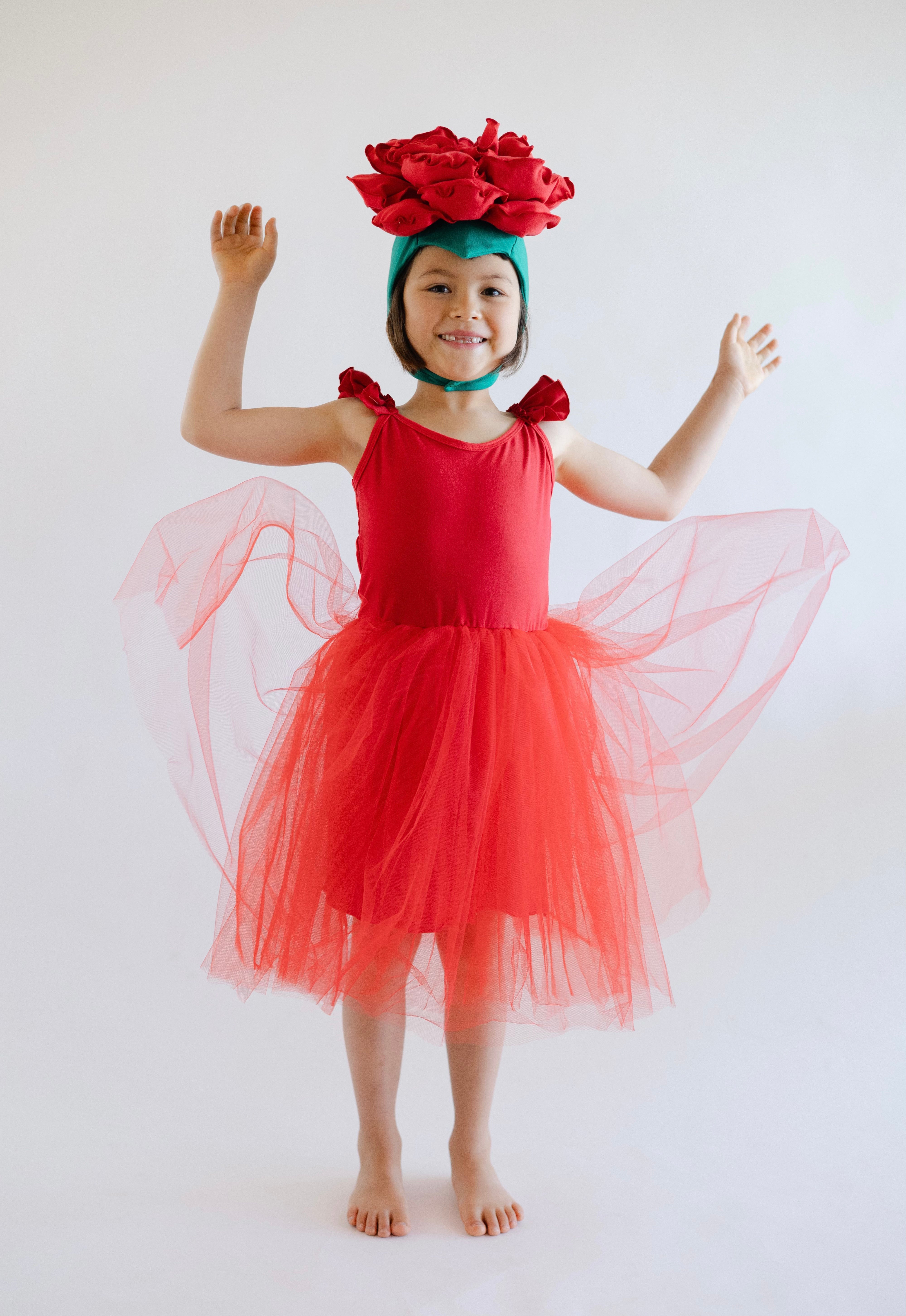 Child in a red dress with flower headband on a white background