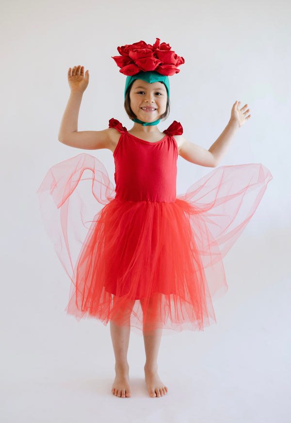 Child in a red dress with flower headband on a white background