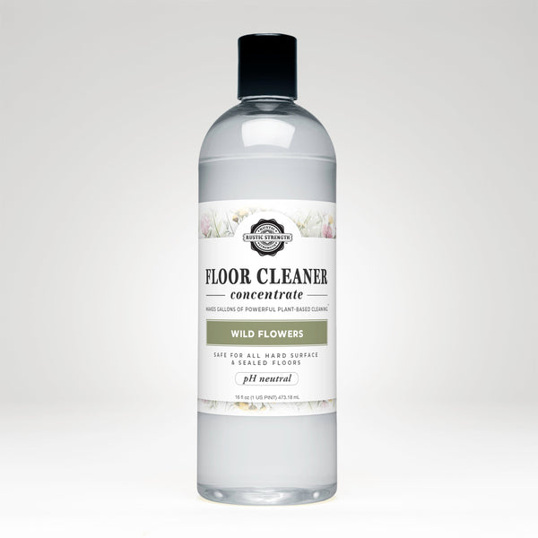 Bottle of floor cleaner concentrate with a label on a white background. Wild Flowers floor cleaner concentrate — non-toxic, plant-based & pH neutral. Makes gallons, safe for kids & pets, 100% biodegradable & ammonia-free. Shop now.