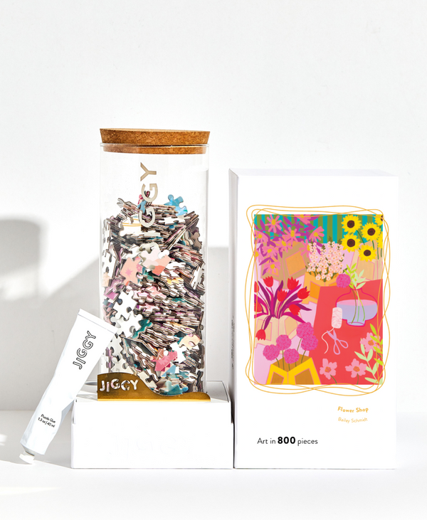 Jigsaw puzzle box with colorful pieces and packaging on a white background
