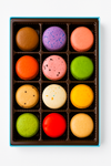 Box of colorful macarons on a white background