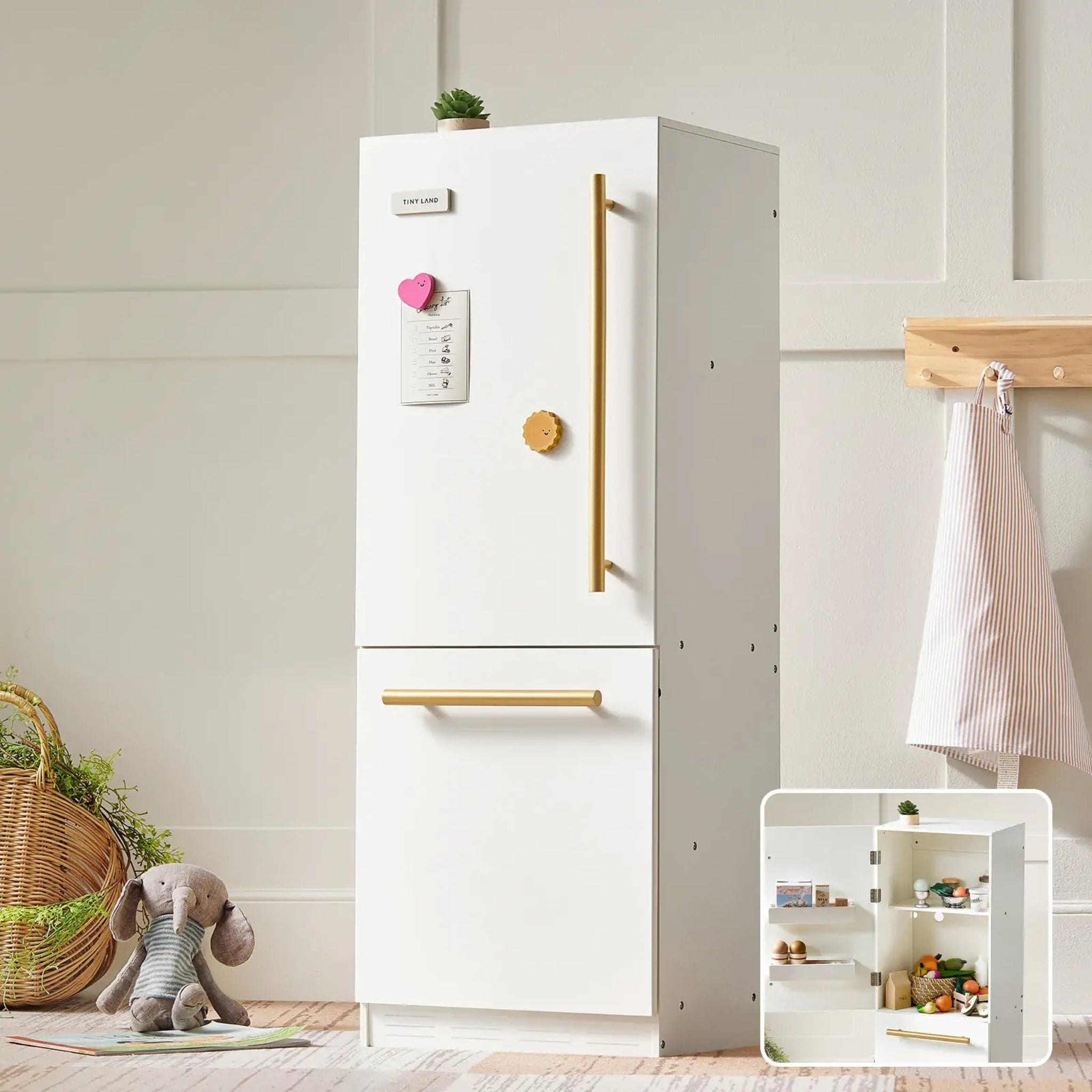 Tiny Land white wooden play kitchen fridge with gold handles styled in a child's bedroom with a teddy bear and wicker basket
