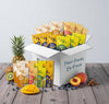 Box of Dole Fruit Faves 24-pack with various fruit snacks on a wooden surface.