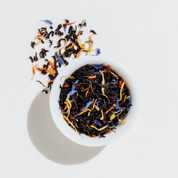 Art of Tea Garden of Eden loose leaf black tea blend with organic marigold, safflowers, and cornflowers in a white bowl