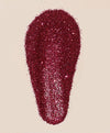 Red glittery makeup product on a beige background