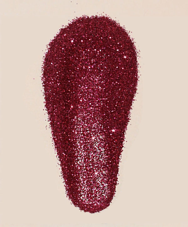 Red glittery makeup product on a beige background