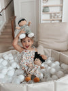 Grady doll in Zebra Print Muslin Coverall next to baby in Earthtone Floral Jumpsuit and Gwen doll in Earthtone Floral doll dress