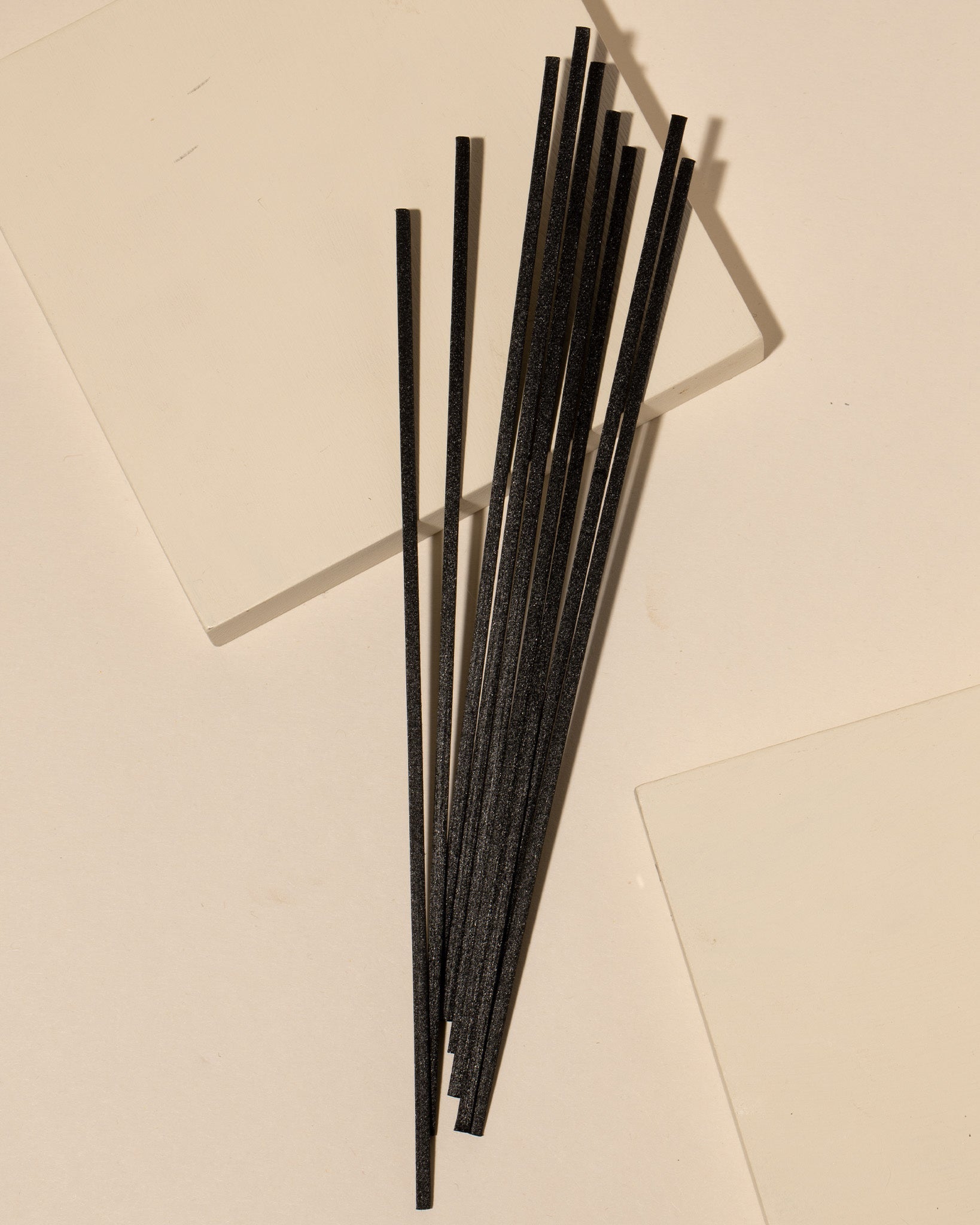 Fiber diffuser reeds displayed in a styled home fragrance setting with diffuser bottle