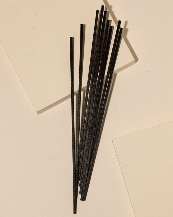 Fiber diffuser reeds displayed in a styled home fragrance setting with diffuser bottle