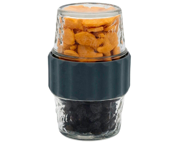 Glass container with a black base holding snacks on a white background