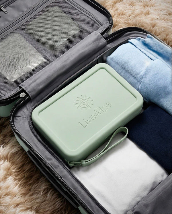 Green travel organizer with 'Live Lite' branding inside an open suitcase with folded clothes.