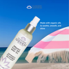 Glimmer Goddess organic dry body oil bottle with beach background