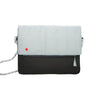 A two-tone messenger bag with a light mint green top flap and a black bottom body, featuring a small red dot logo on the flap, a gray and white patterned shoulder strap, and a tassel zipper pull on a white background.