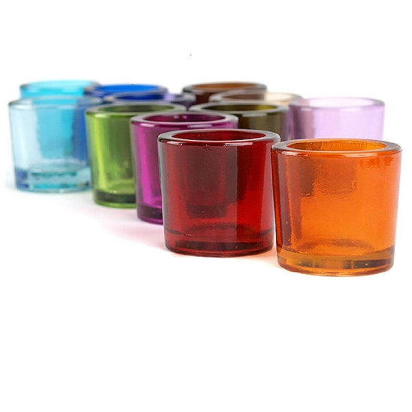 Set of colorful glass votive candle holders on a white background