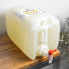 Large plastic container with a pump on a wooden surface