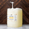 Large container of hand soap with a pump on a wooden background