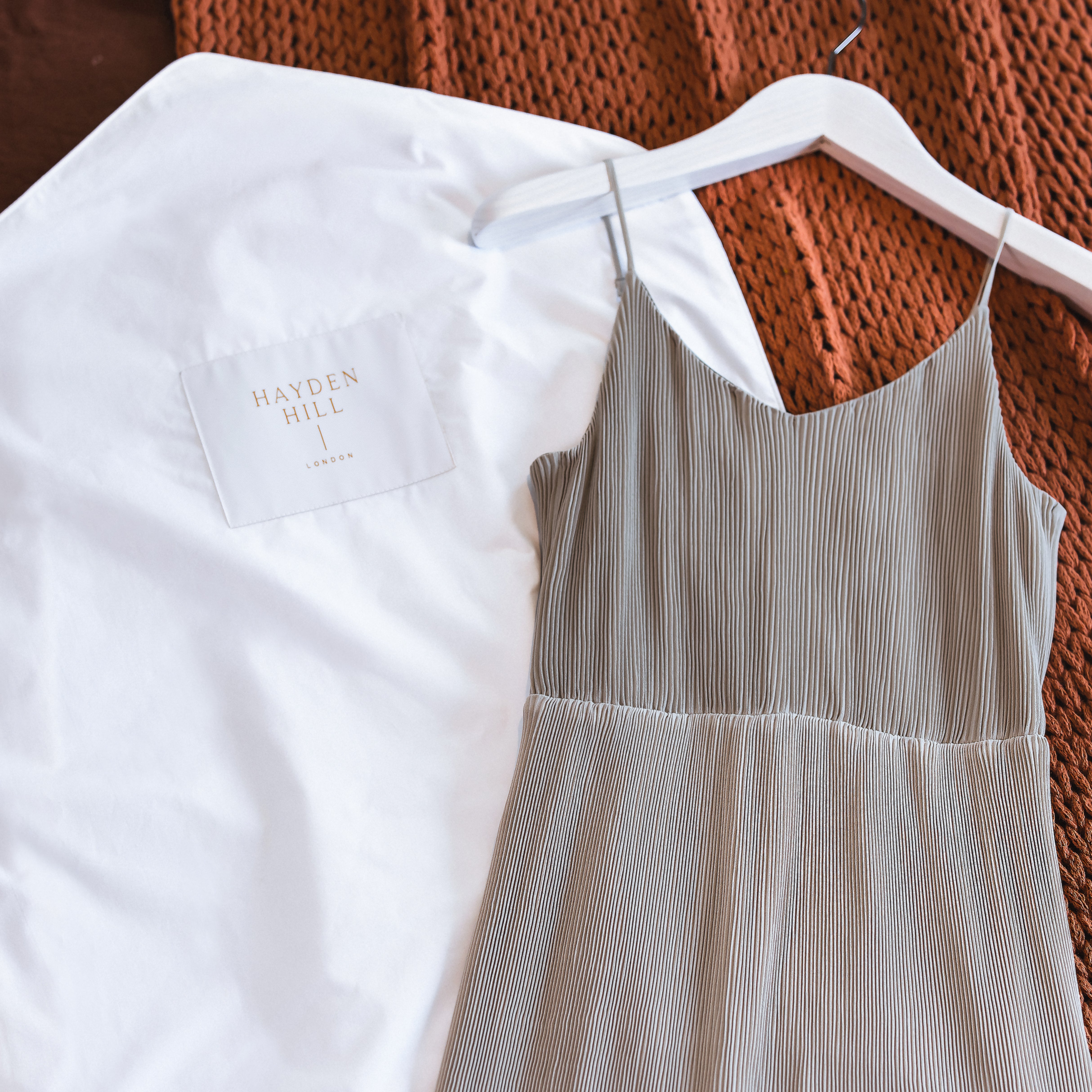 Long organic cotton hanging storage bag for dresses laid flat showing see-through organza panel