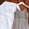 Long organic cotton hanging storage bag for dresses laid flat showing see-through organza panel