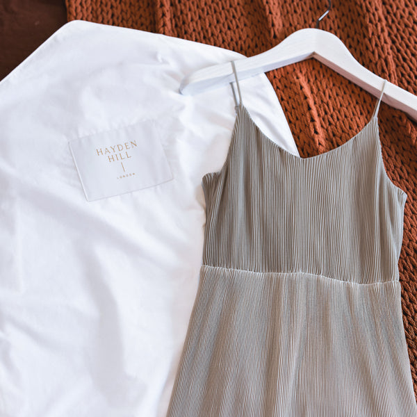 Long organic cotton hanging storage bag for dresses laid flat showing see-through organza panel