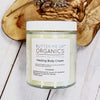 Butter Me Up Organics Healing Body Cream jar on a wooden surface