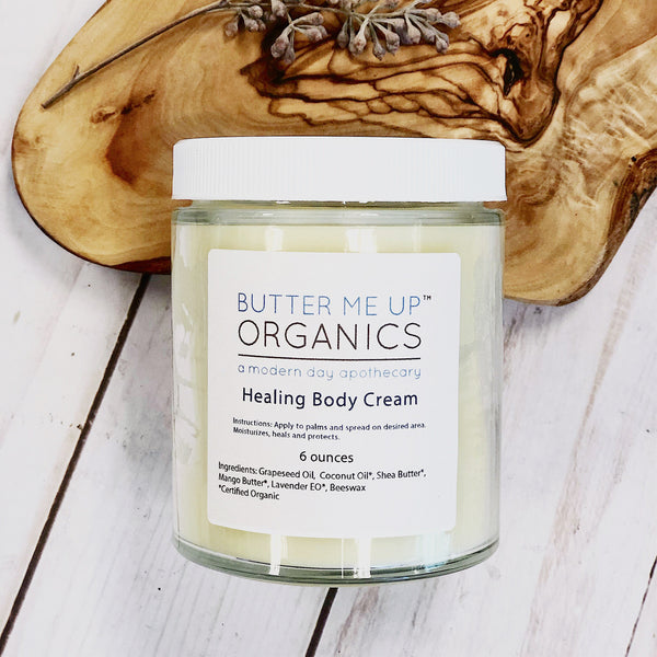 Butter Me Up Organics Healing Body Cream jar on a wooden surface