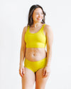 Woman wearing Thunderpants Star Fruit Hipster underwear in yellow chartreuse, front view