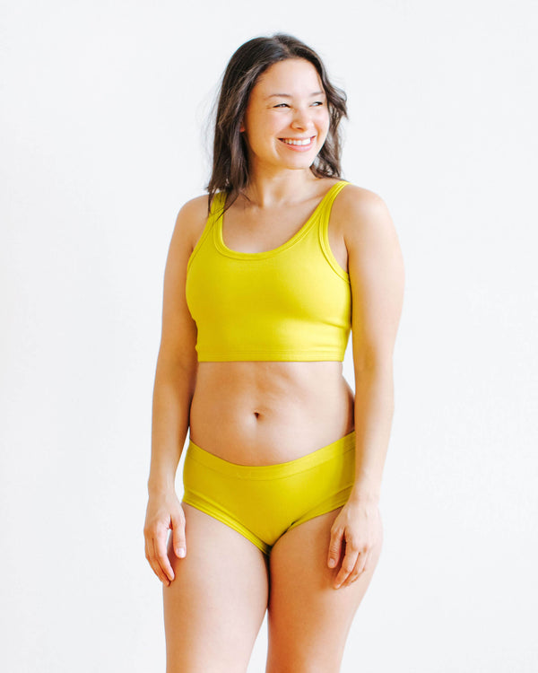 Woman wearing Thunderpants Star Fruit Hipster underwear in yellow chartreuse, front view