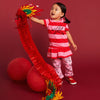 Child playing with a red dragon toy against a red background