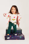 Baby wearing Mon Coeur organic cotton flower print long-sleeve t-shirt in natural setting