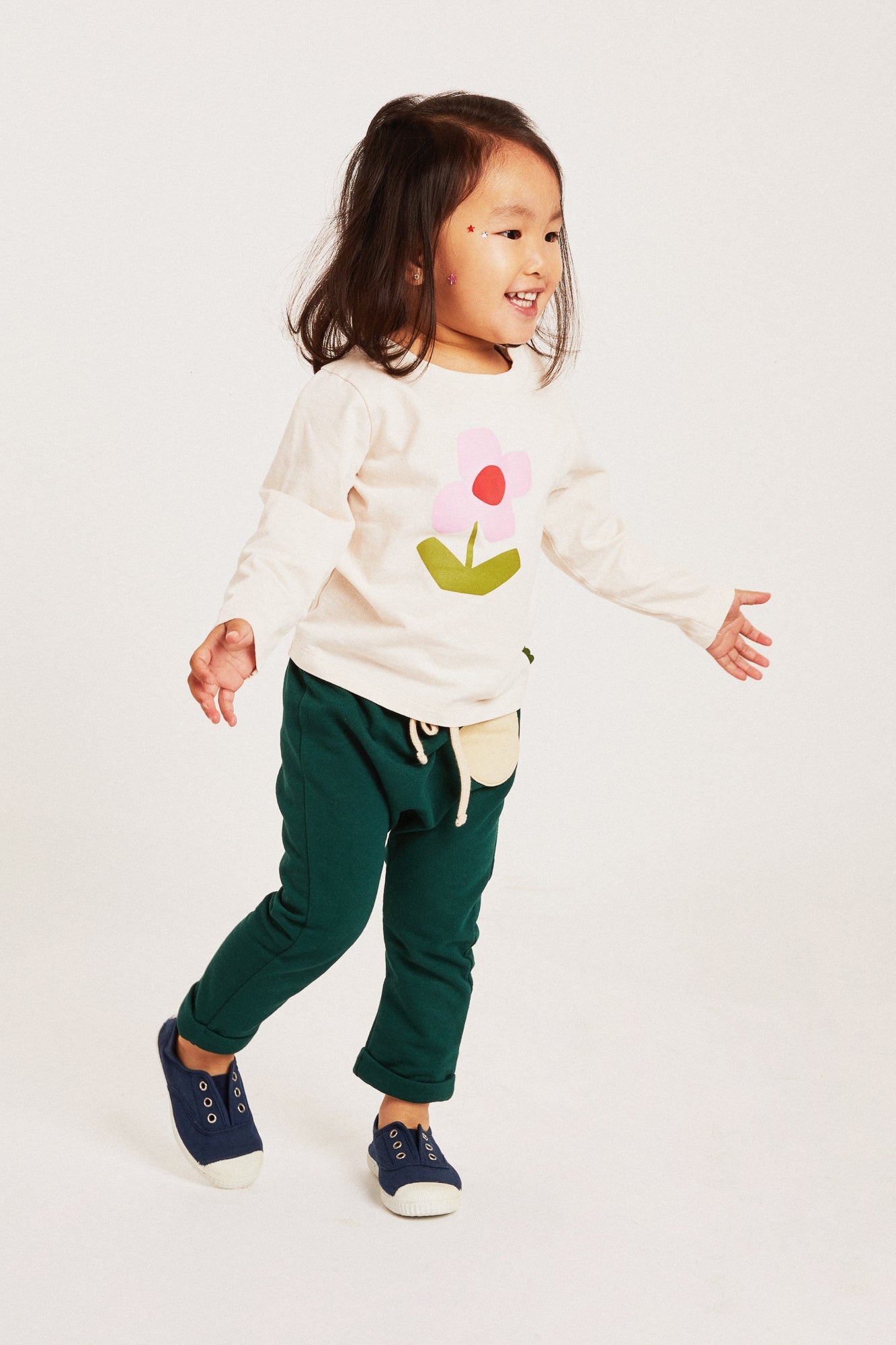 Close-up of Mon Coeur flower print baby t-shirt showing fabric detail and sleeve