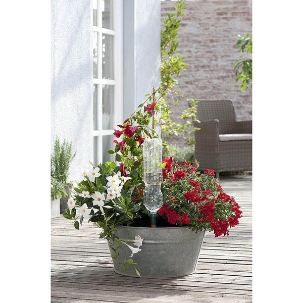 Decorative planter with flowers and a solar light on a wooden deck.