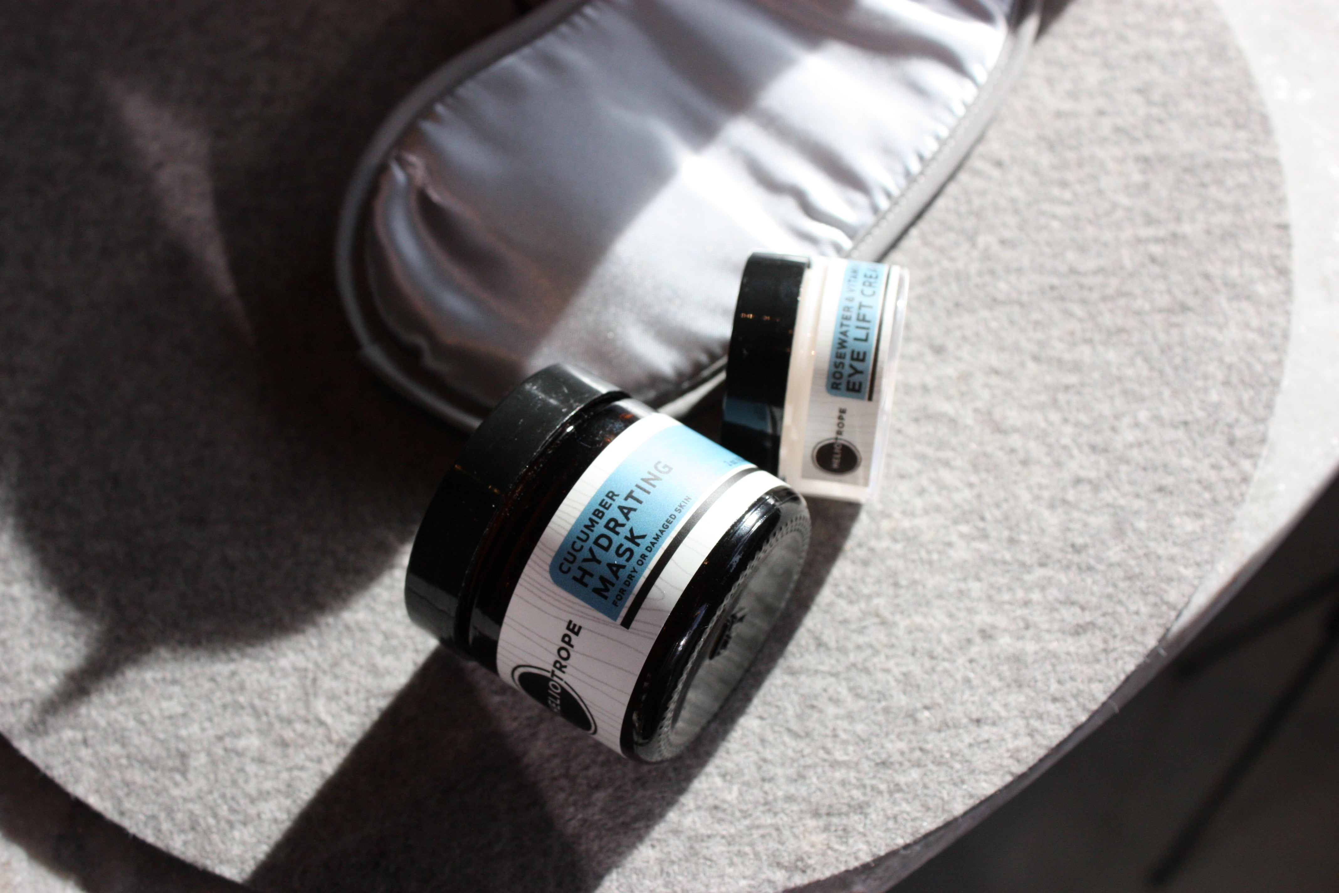 Heliotrope SF eye lift cream styled with a face mask — natural skincare flatlay