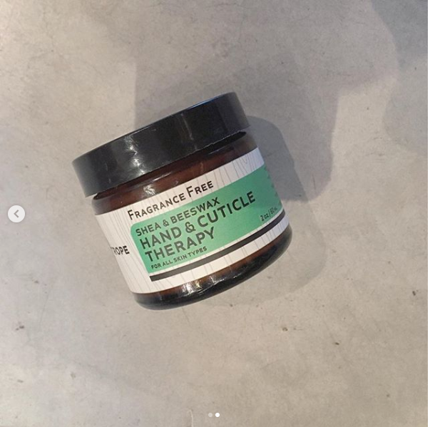 Close-up of Heliotrope SF Hand and Cuticle Therapy cream being applied to hands and cuticles
