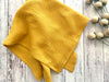 Yellow fabric on a wooden surface with decorative elements
