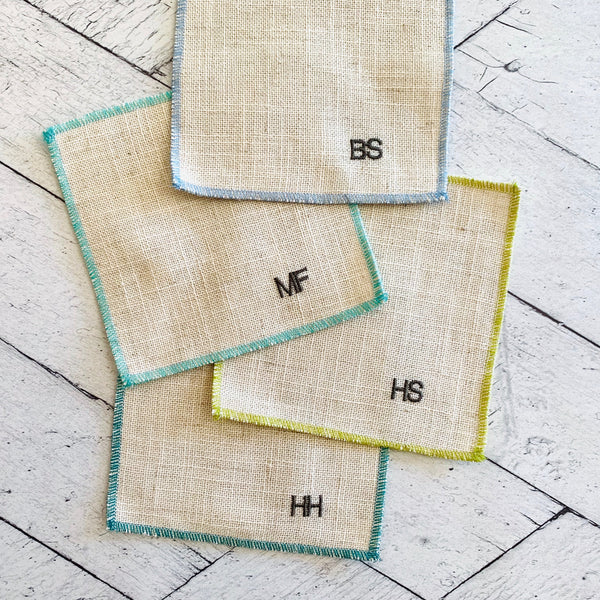 Close-up of sweary cocktail coasters handmade by Dot and Army, showing embroidered letter detail on linen fabric