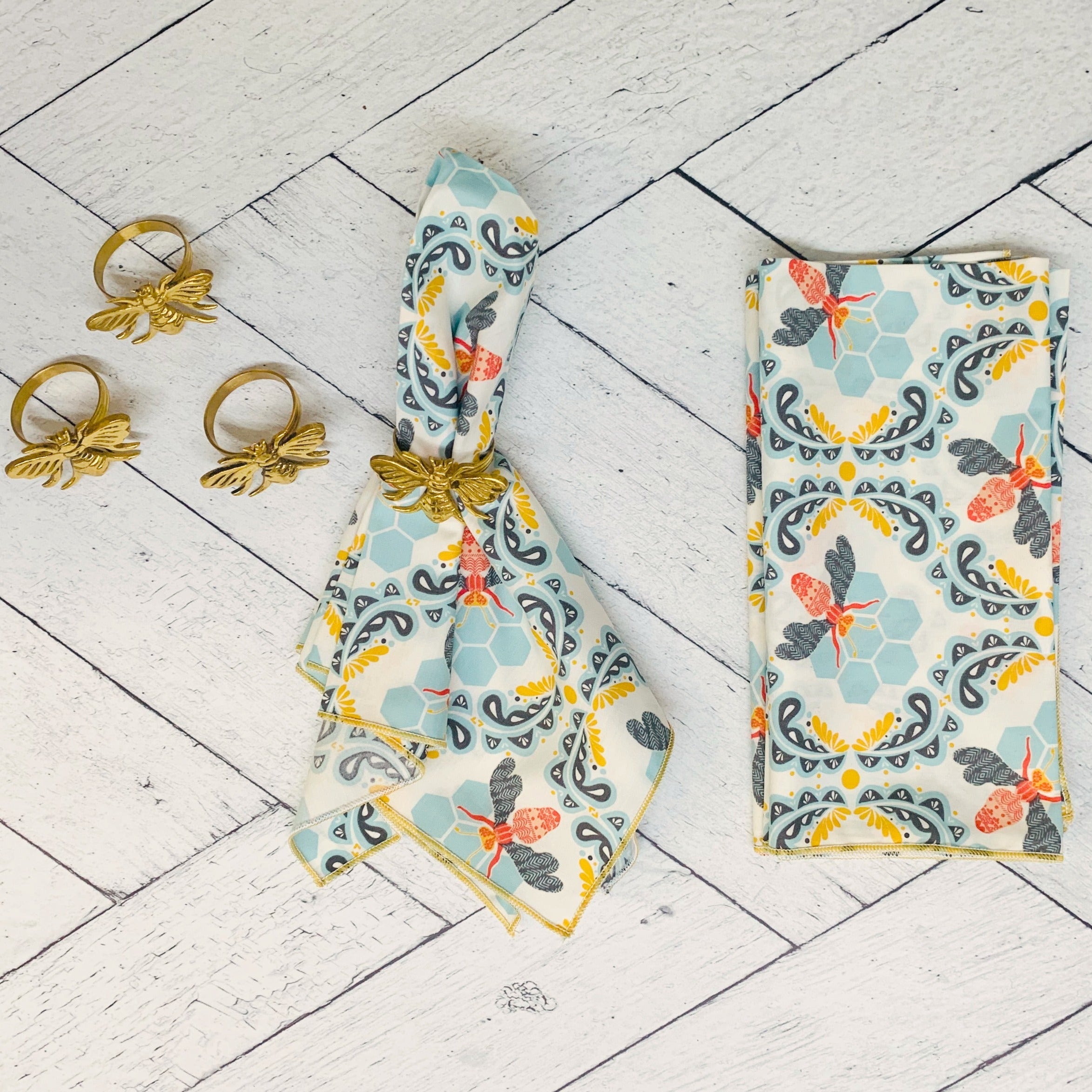 Honey bee cloth napkins set of four in 100% cotton, folded neatly on a table