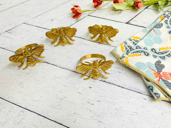 Honey bee cloth napkins styled on a place setting with bee napkin rings
