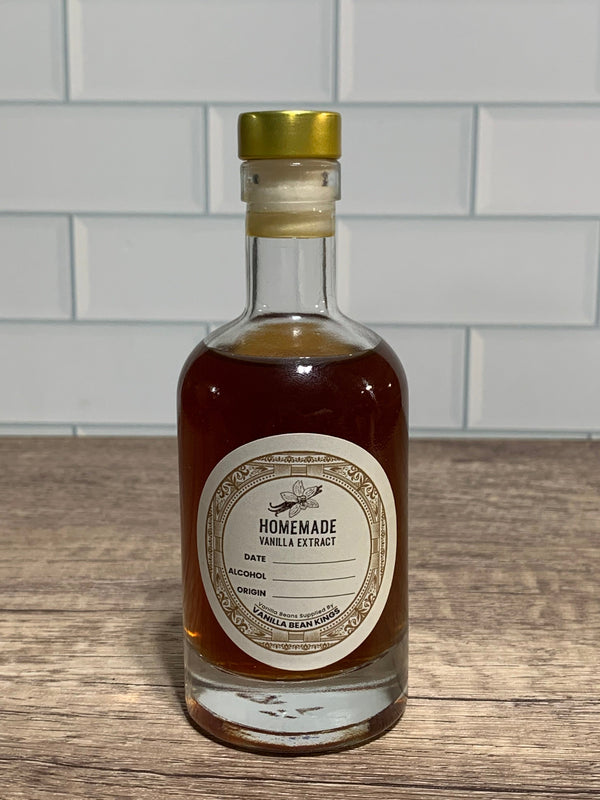 Bottle of homemade vanilla extract on a wooden surface with a tiled wall background