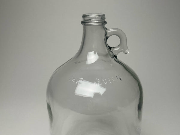 Rustic Strength 1 gallon glass jug showing full body and secure screw-top cap