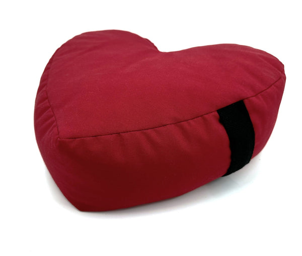 Red heart-shaped pillow with a black stripe on a white background