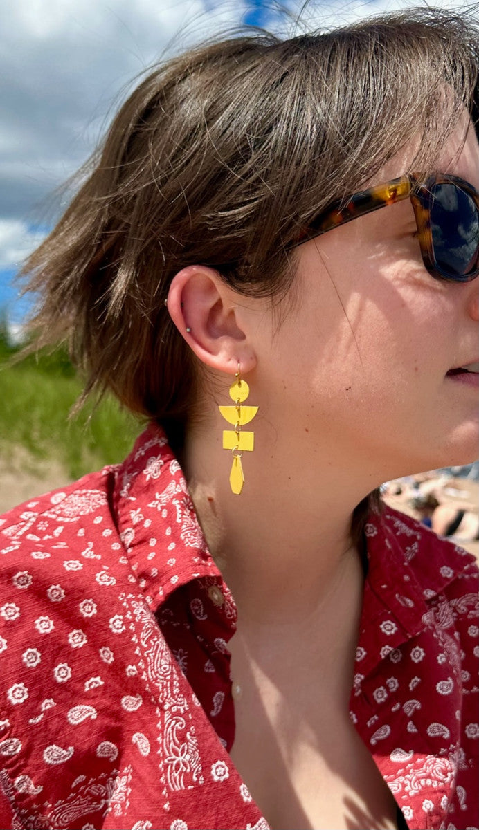Model wearing Fair Anita pagoda painted drop earrings in red geometric style