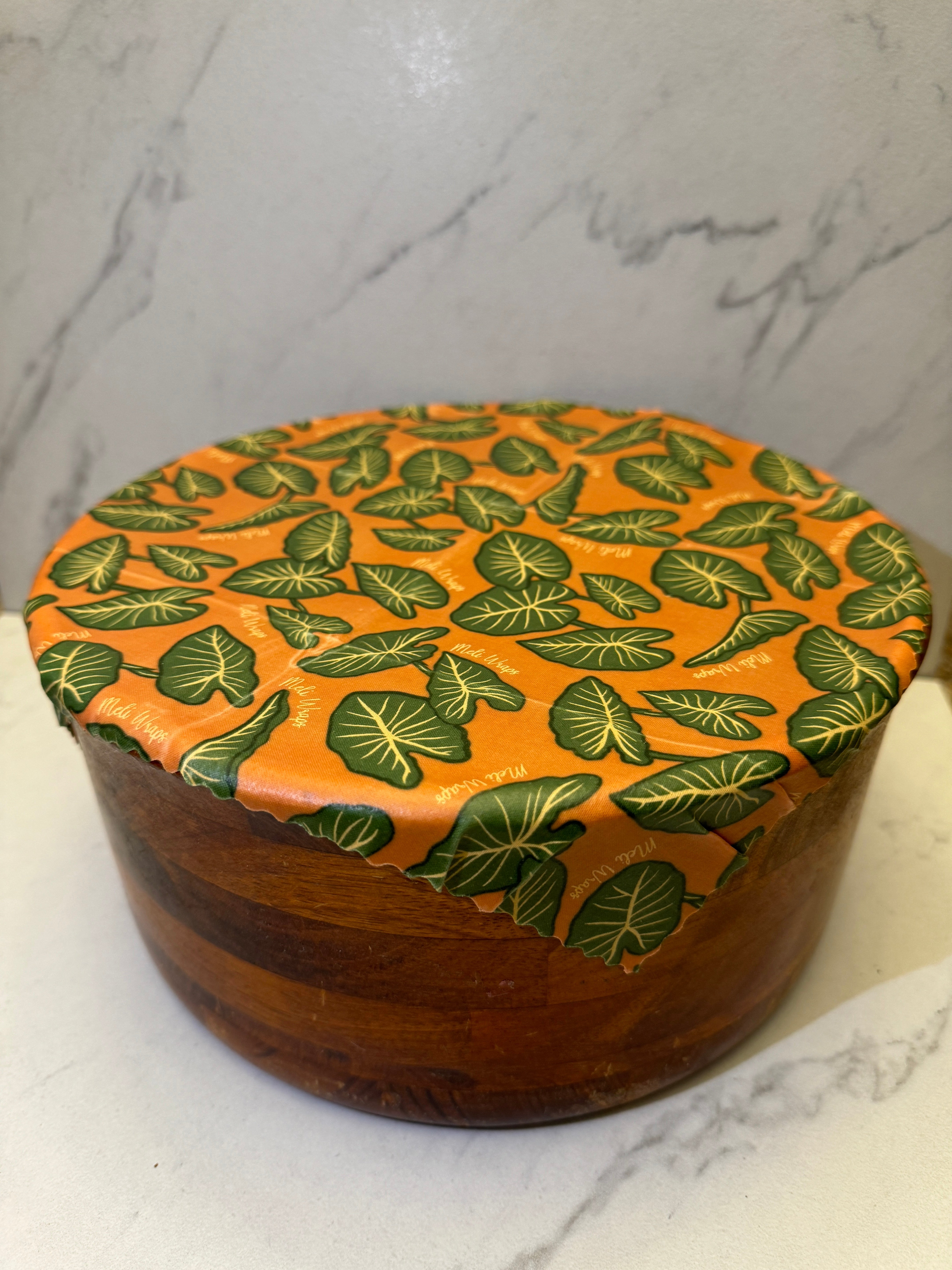Kalo print beeswax wrap molded around a bowl for food storage