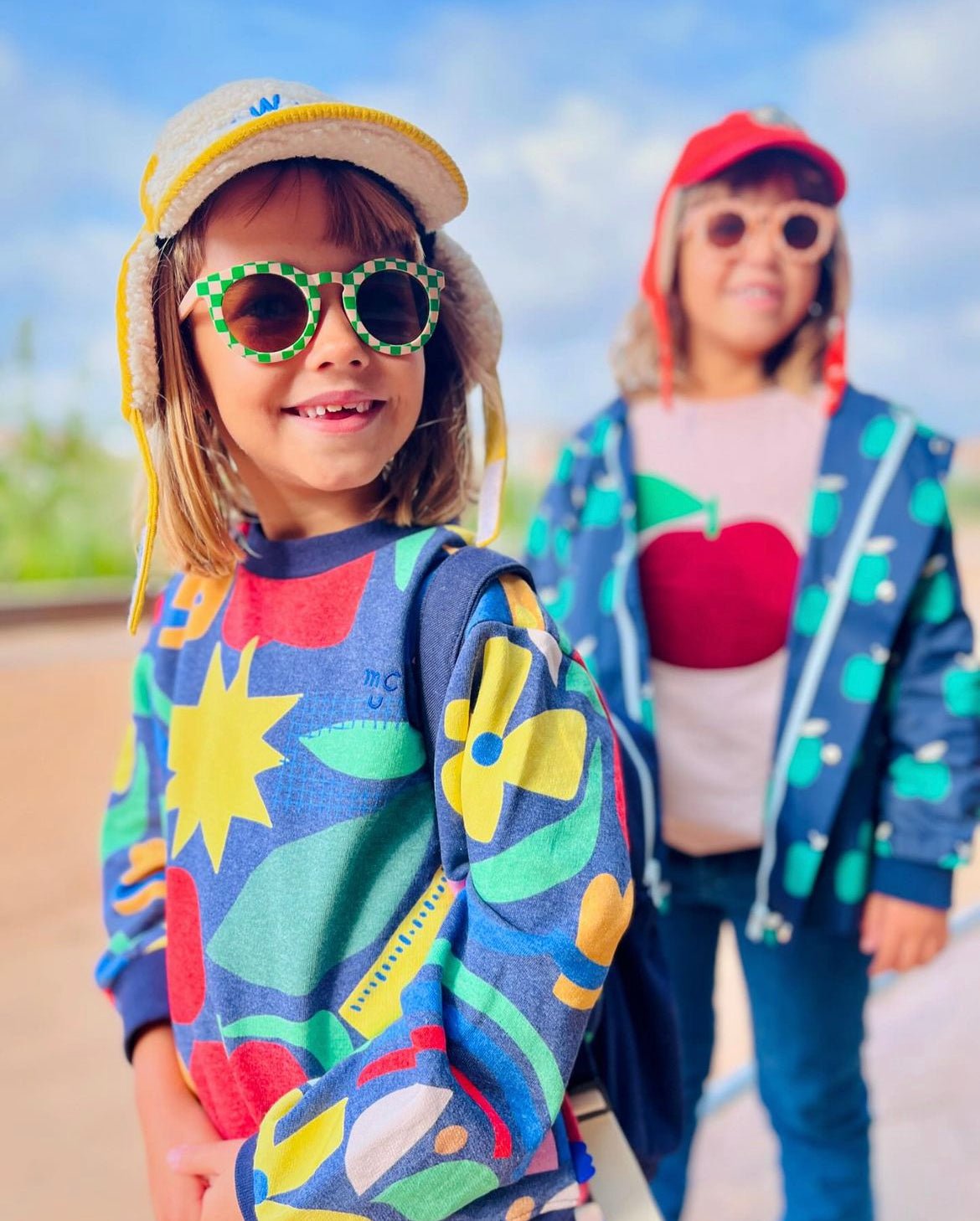 Back view of Mon Coeur recycled cotton kids sweatshirt showing all-over multicolor pattern and ribbed hem