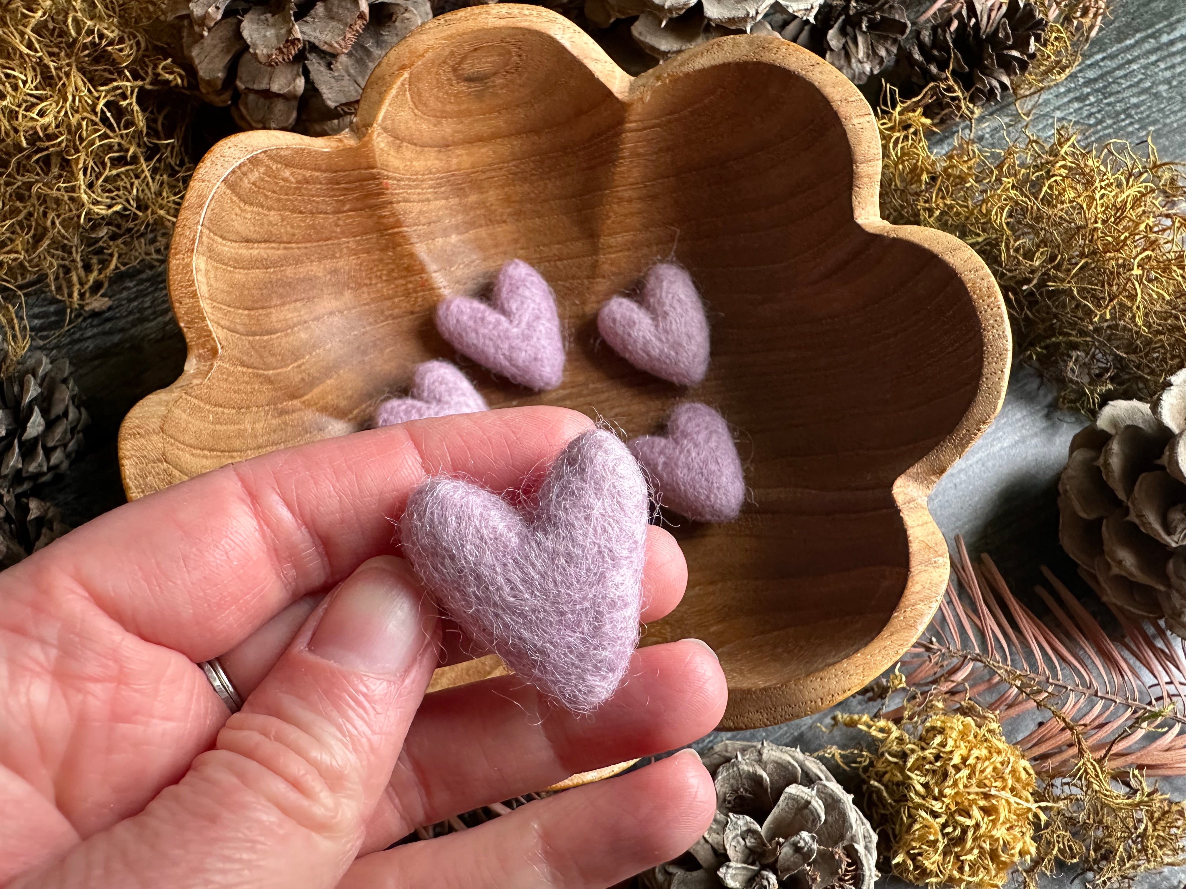 Close view of needle-felted wool hearts in Anemone Purple, each slightly different in shape
