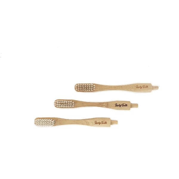 Three bamboo toothbrushes with 'Simply Teeth' branding on a white background