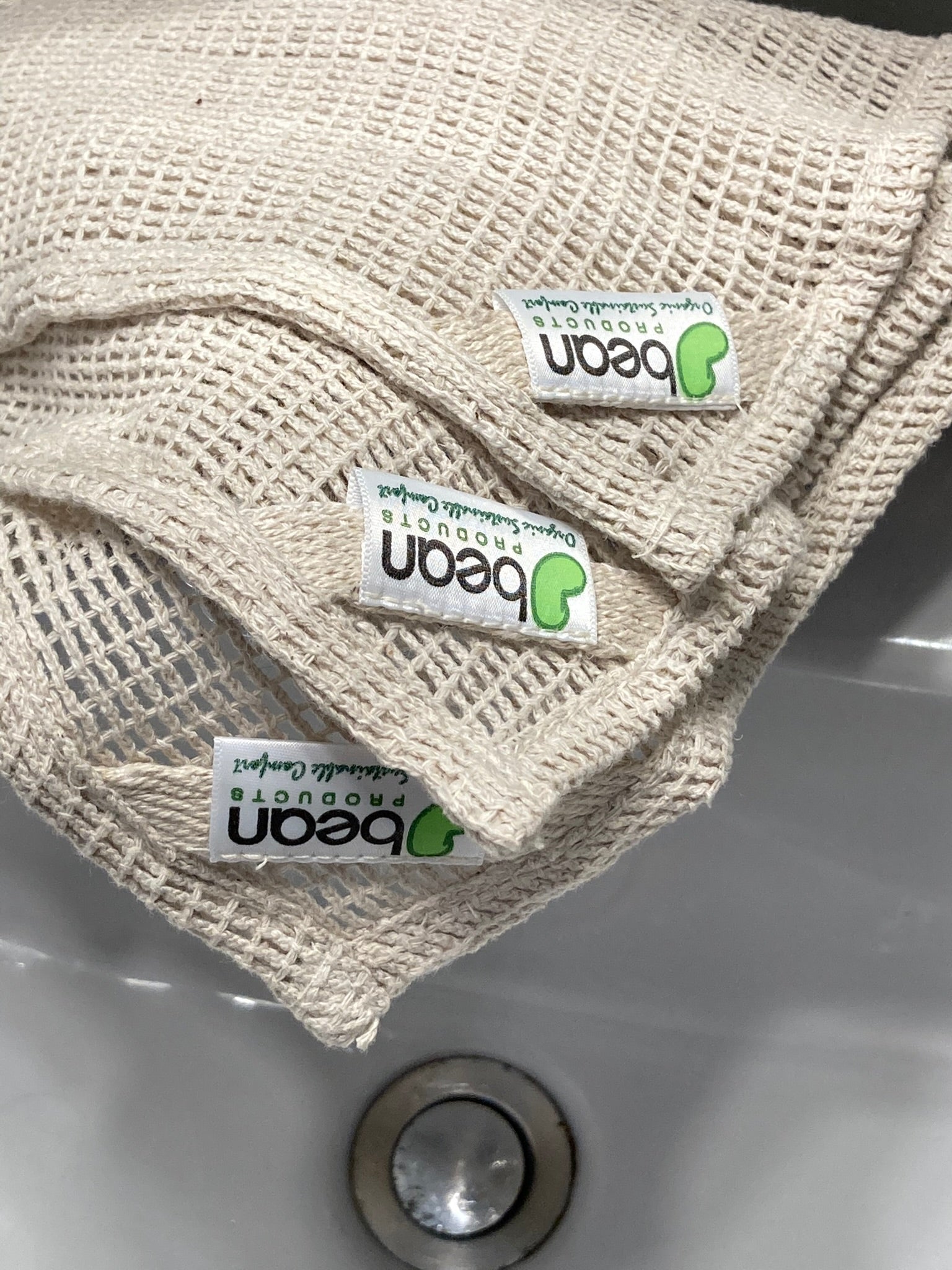 Beige washcloth with 'peaon' labels on a sink