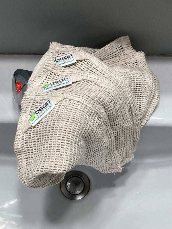 Beige mesh scrubber with 'bear' branding on a sink