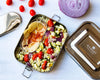 Ecozoi plastic-free stainless steel lunch box filled with a fresh meal, top-down view