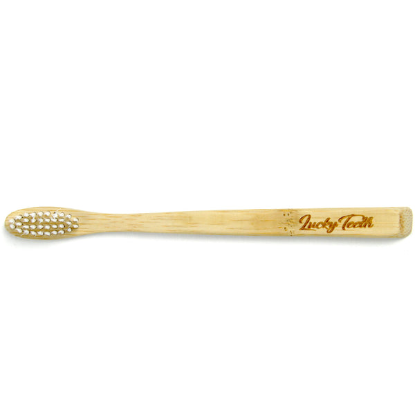 Bamboo toothbrush with 'Lucky Teeth' branding on a white background