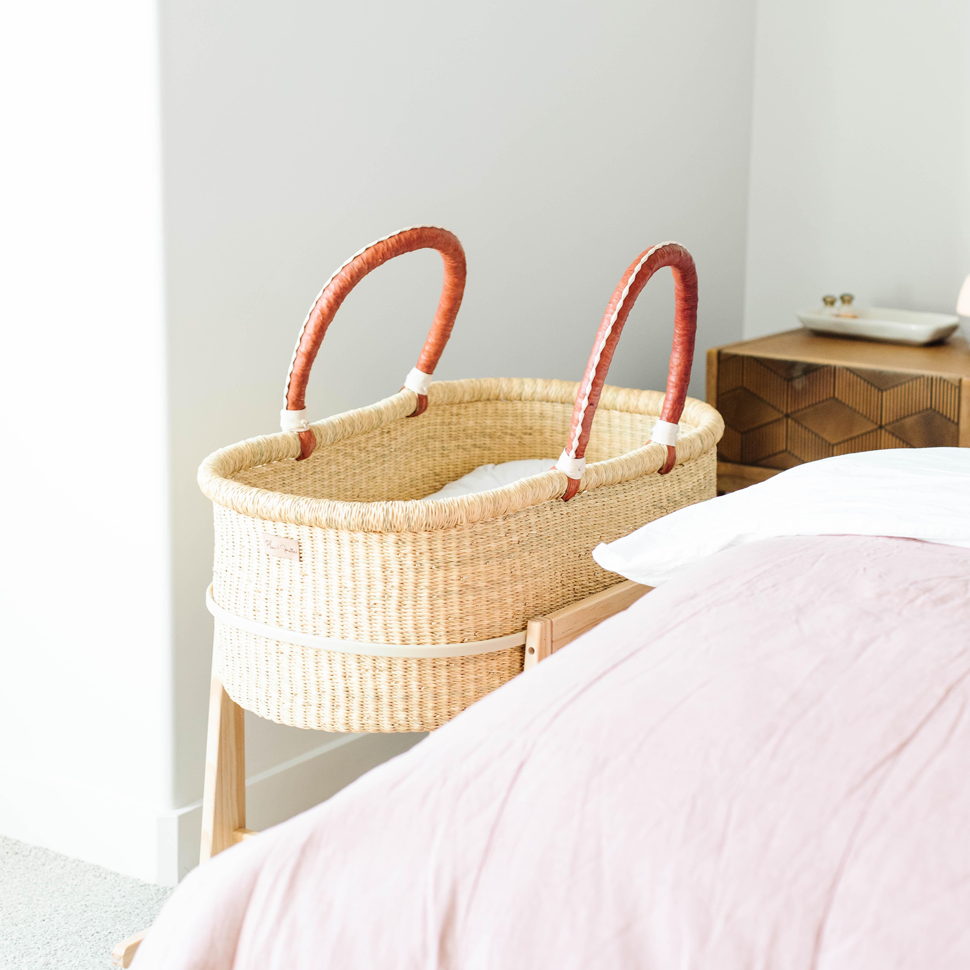 Close-up of the rocking Moses basket stand brake mechanism in natural pine wood